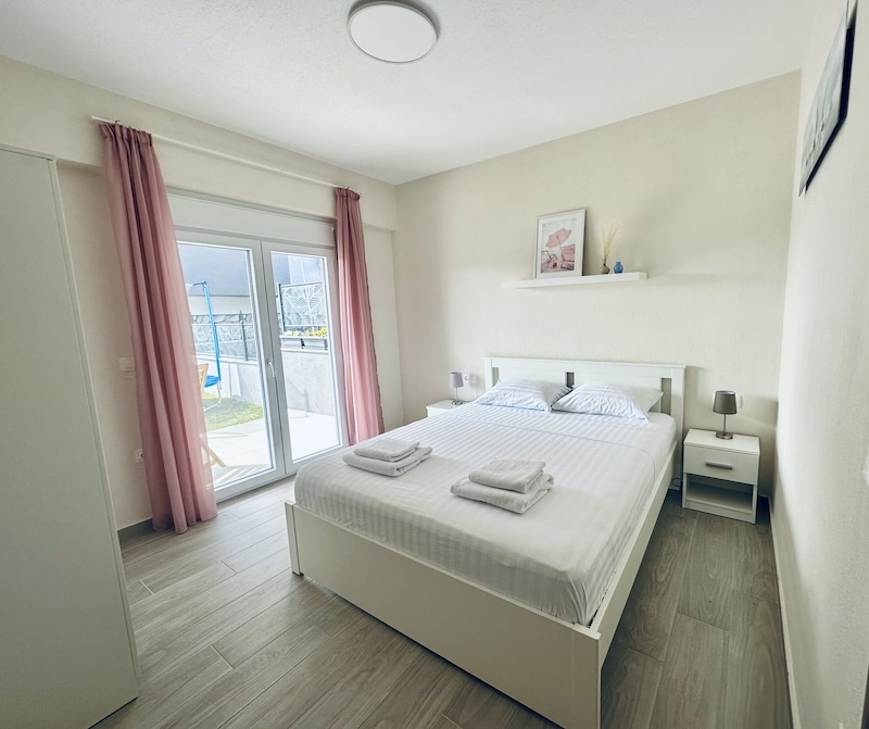 Main bedroom of Lora Family Apartment in Nikiti with king-size bed, garden view, and cozy decor